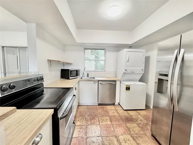 a kitchen that has a sink a counter top space stainless steel appliances and cabinets