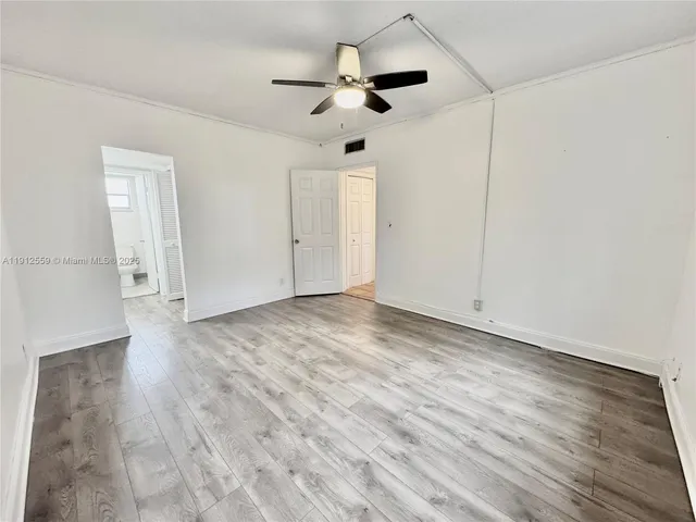 a view of empty room with wooden floor