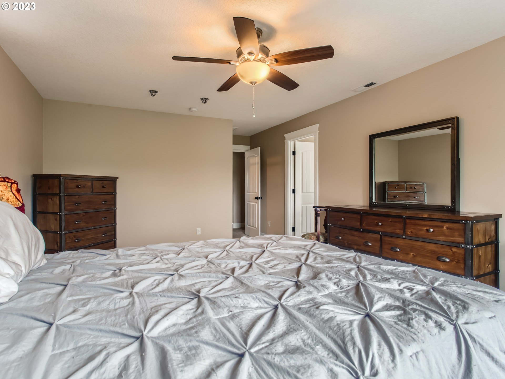 4404 North 4th Circle Ridgefield, WA 98642 - Photo 14 of 29 a bedroom with a large bed and a chandelier