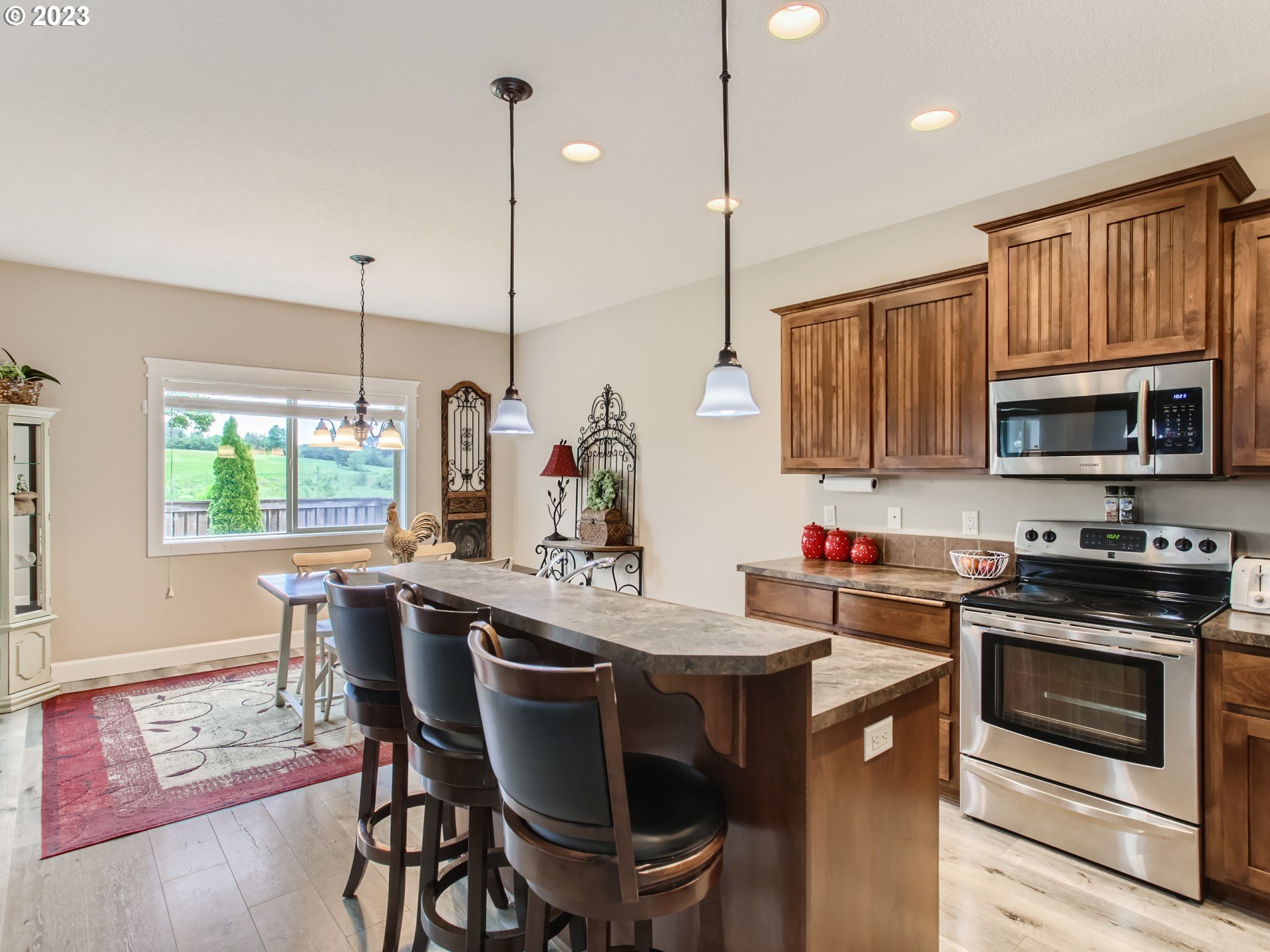 4404 North 4th Circle Ridgefield, WA 98642 - Photo 9 of 29 a kitchen with a stove a sink a microwave a dining table and chairs