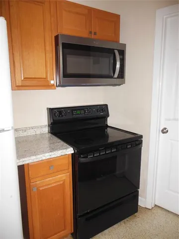 a kitchen with stainless steel appliances wooden cabinets and a stove top oven