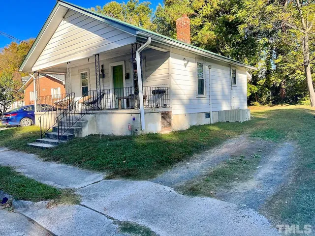 a view of house with backyard and sitting area
