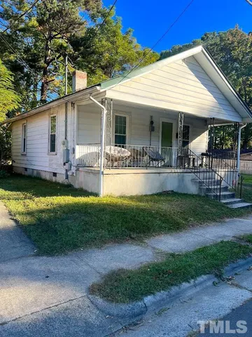 a view of a house with a yard patio and a small yard