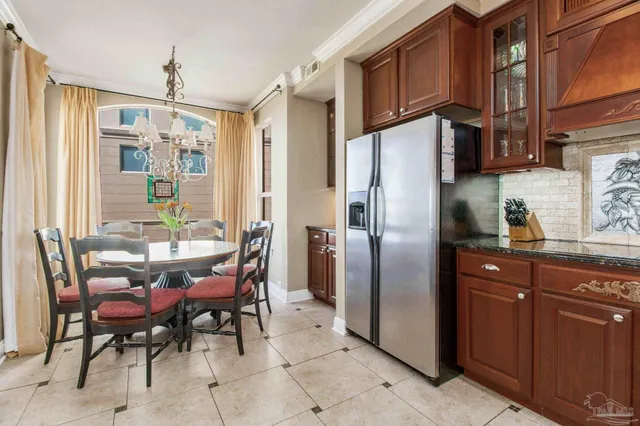 a kitchen with stainless steel appliances a refrigerator and a table chair