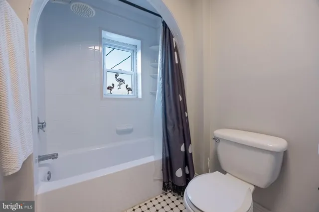a white toilet sitting next to a bath tub