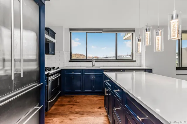 a kitchen with stainless steel appliances granite countertop a sink and a stove