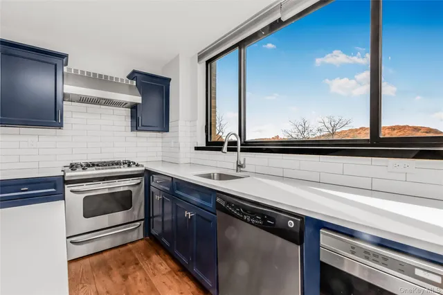 a kitchen with stainless steel appliances a sink stove and microwave