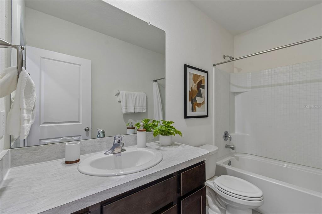 33083 Frosted Clover Way Wesley Chapel, FL 33545 - Photo 14 of 70 a bathroom with a granite countertop toilet a sink and a mirror