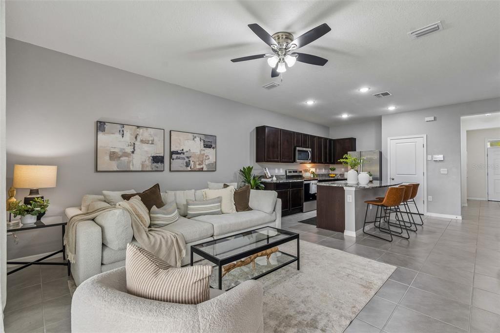 33083 Frosted Clover Way Wesley Chapel, FL 33545 - Photo 34 of 70 a living room with furniture kitchen view and a chandelier