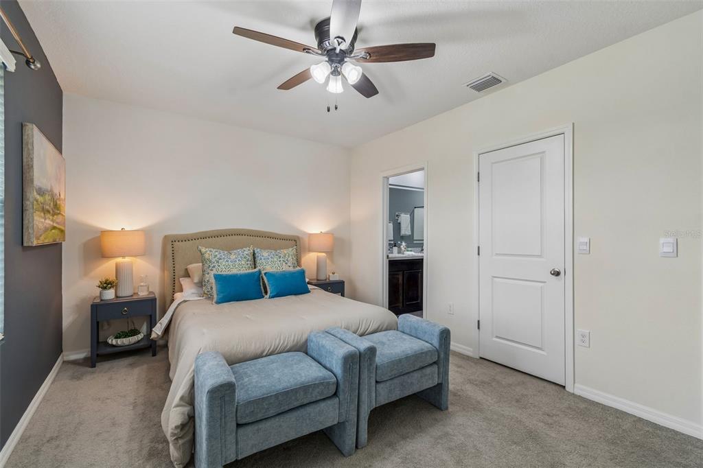 33083 Frosted Clover Way Wesley Chapel, FL 33545 - Photo 36 of 70 a bedroom with a bed and a chandelier