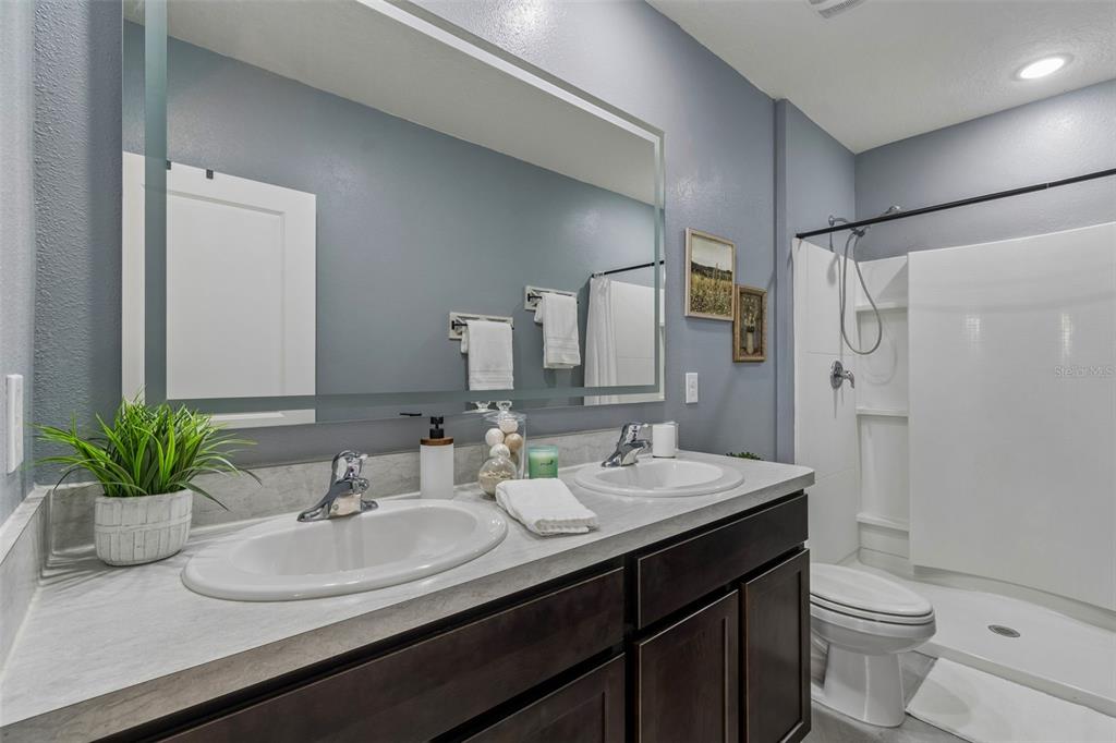 33083 Frosted Clover Way Wesley Chapel, FL 33545 - Photo 10 of 70 a bathroom with a double vanity sink toilet and a mirror