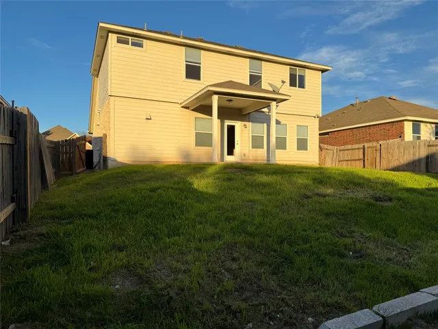 a view of a yard with brick wall and a large tree