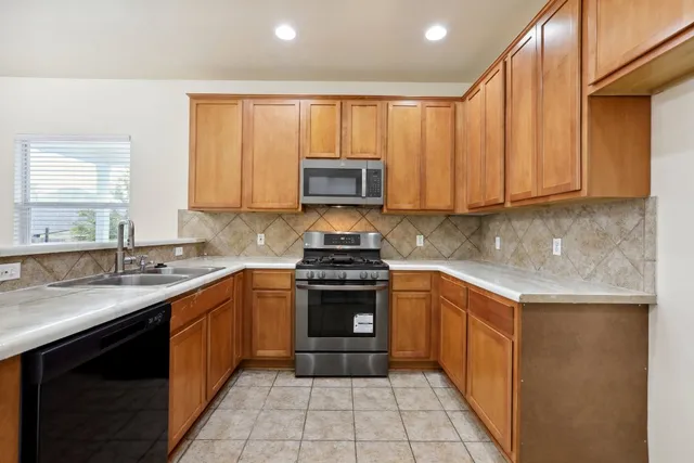 a kitchen with a sink stove top oven and cabinets