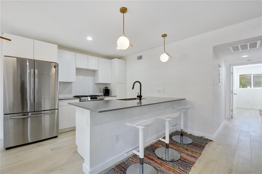 400 East 30th Street, Unit 204 Austin, TX 78705 - Photo 7 of 18 a kitchen with sink cabinets and stainless steel appliances