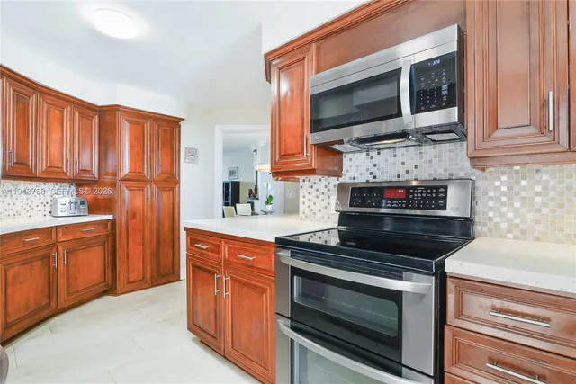 a kitchen with stainless steel appliances granite countertop a stove microwave and sink