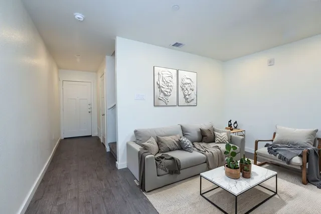 a living room with furniture and wooden floor