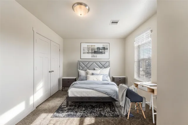 a bed sitting in a bedroom next to a window