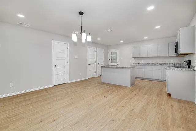 a view of a kitchen with a sink wooden cabinets and stainless steel appliances