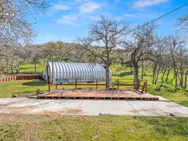 a view of a house with backyard and trees