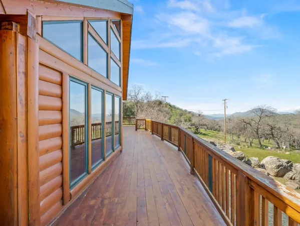 a view of a balcony with wooden floor and fence