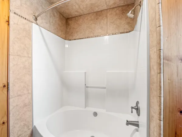 a bathroom with a white bath tub and a shower