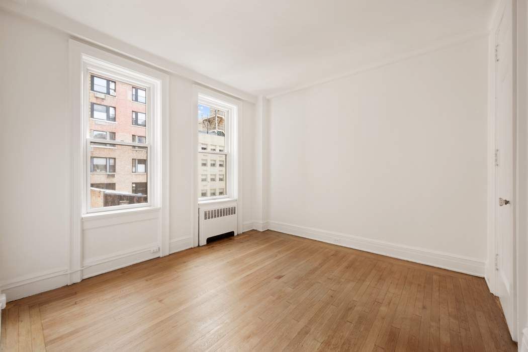 103 East 84th Street, Unit 6B Manhattan, NY 10028 - Photo 9 of 19 an empty room with windows