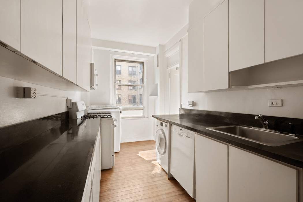 103 East 84th Street, Unit 6B Manhattan, NY 10028 - Photo 12 of 19 a kitchen with granite countertop a sink a stove and cabinets
