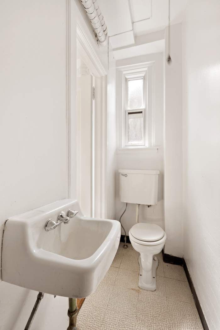 103 East 84th Street, Unit 6B Manhattan, NY 10028 - Photo 15 of 19 a bathroom with a sink a toilet and a window
