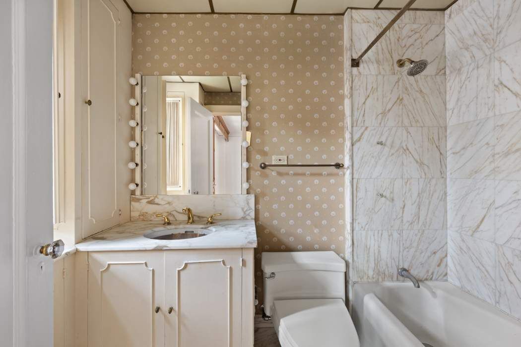 103 East 84th Street, Unit 6B Manhattan, NY 10028 - Photo 7 of 19 a bathroom with a granite countertop sink toilet and shower
