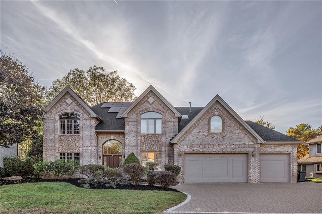 a front view of a house with a garden and plants