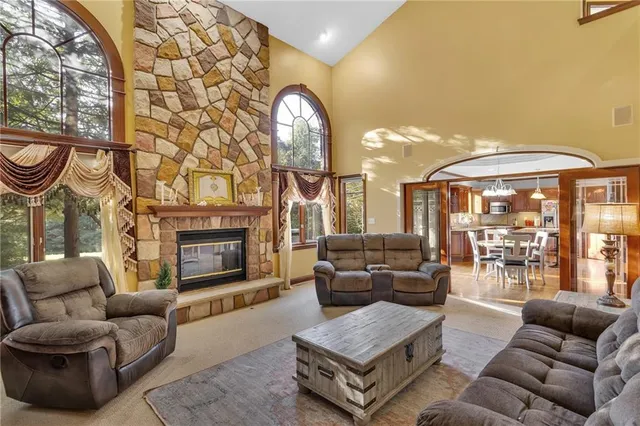 a living room with furniture a fireplace and a large window