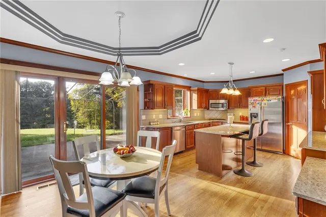 a dining room with furniture a chandelier and wooden floor