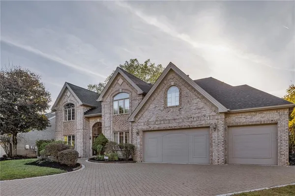 a front view of a house with a garden and garage