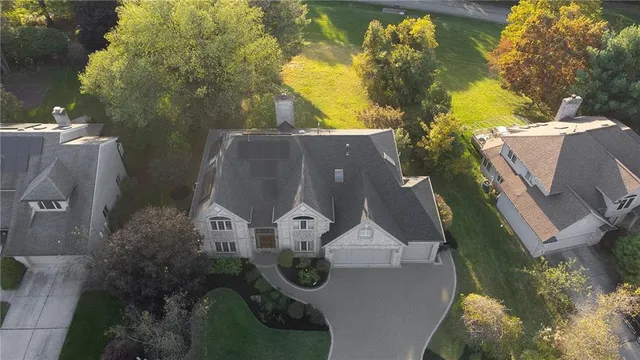 an aerial view of a house with a yard and large trees
