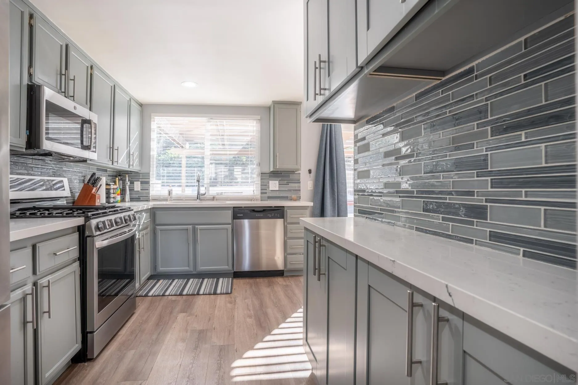 4857 Northerly Street Oceanside, CA 92056 - Photo 12 of 32 a kitchen with stainless steel appliances a sink stove and cabinets