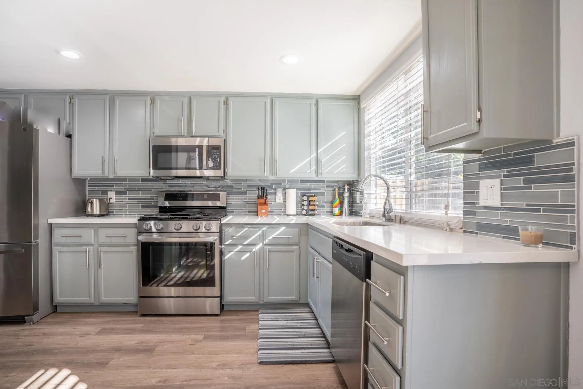 4857 Northerly Street Oceanside, CA 92056 - Photo 13 of 32 a kitchen with a sink stove top oven and refrigerator