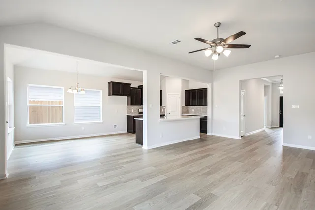 a view of a kitchen with an empty room and window