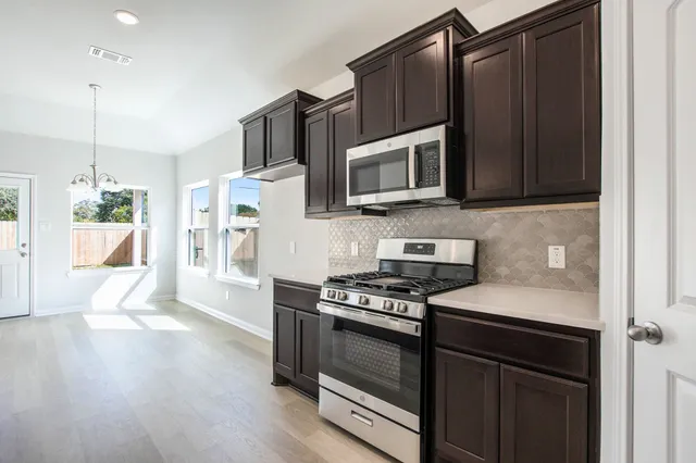 a kitchen with granite countertop wooden cabinets and black appliances