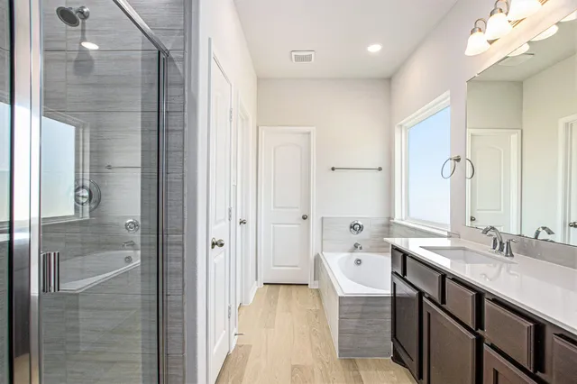 a spacious bathroom with a granite countertop sink a mirror and a shower