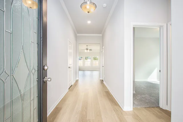 a view of a hallway with wooden floor and closet