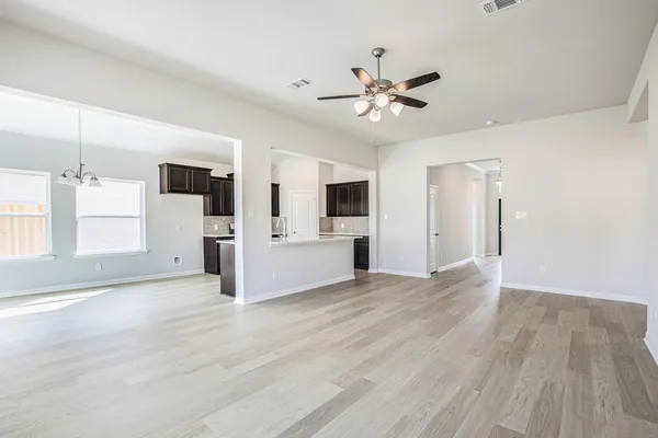 a view of an empty room with wooden floor