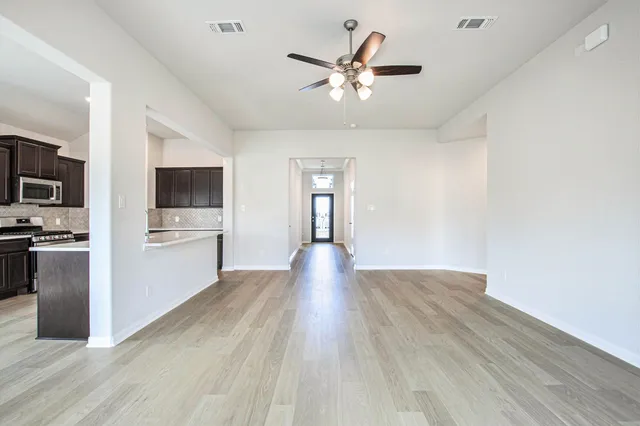 a view of a kitchen with a sink stove cabinets and empty room