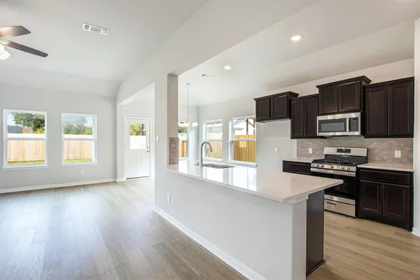 a kitchen with stainless steel appliances granite countertop a sink stove and refrigerator