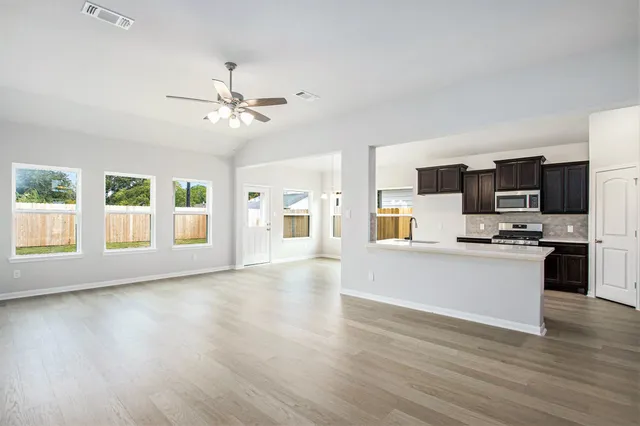 a view of a kitchen with microwave and wooden floor