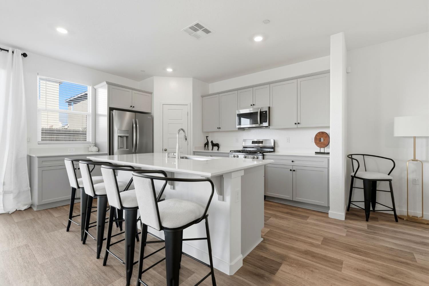 4225 Hampton Way Clovis, CA 93619 - Photo 22 of 64 a kitchen with stainless steel appliances granite countertop a table chairs sink refrigerator and cabinets