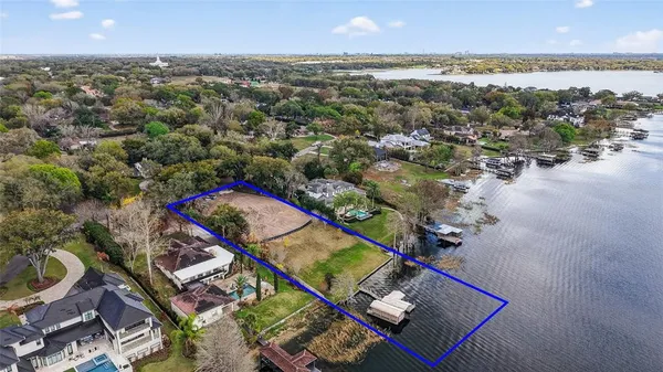 an aerial view of a house with a yard and lake view