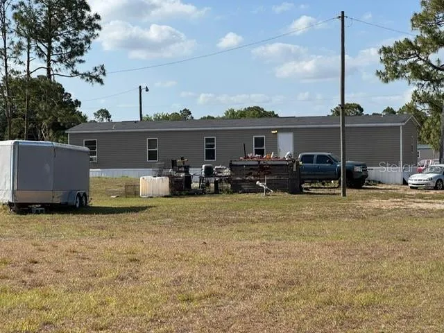 a view of a house with backyard and roof