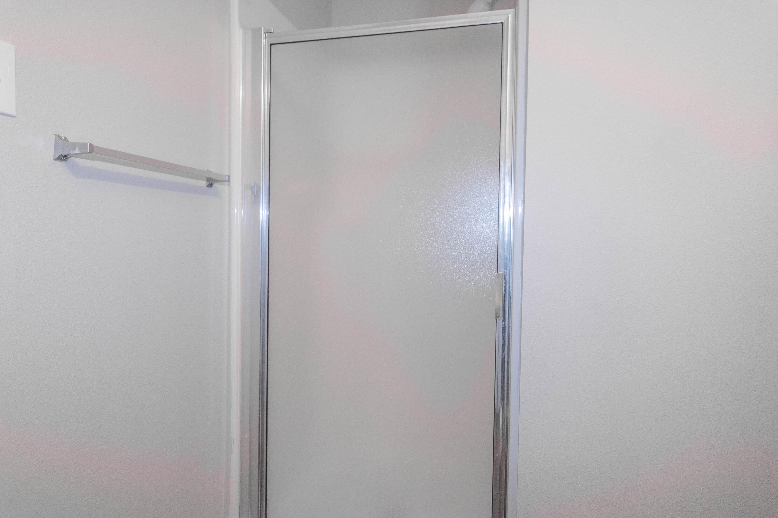 2409 87th Street, Unit B Lubbock, TX 79423 - Photo 10 of 11 a bathroom with a glass shower door