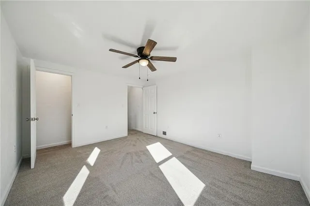 a view of a livingroom with a ceiling fan & a window