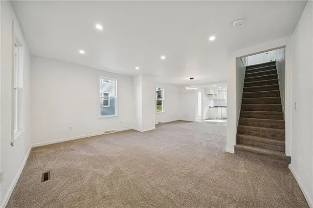 a view of an empty room with closet and entryway